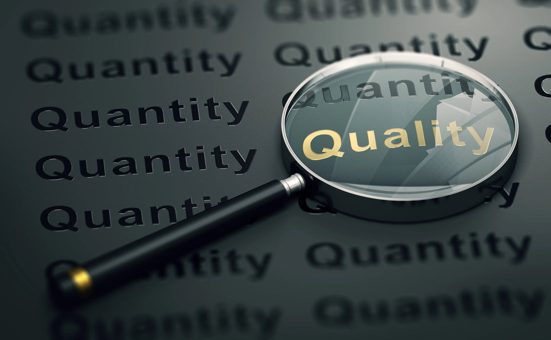 magnifying glass finding the word quality amongst  quantity