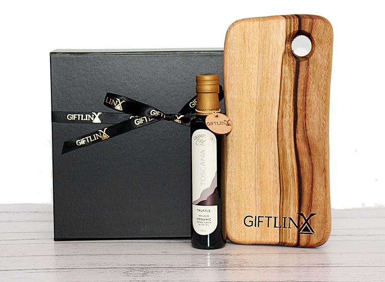 black gift box with branded ribbon standing behind a cheese board with company branding