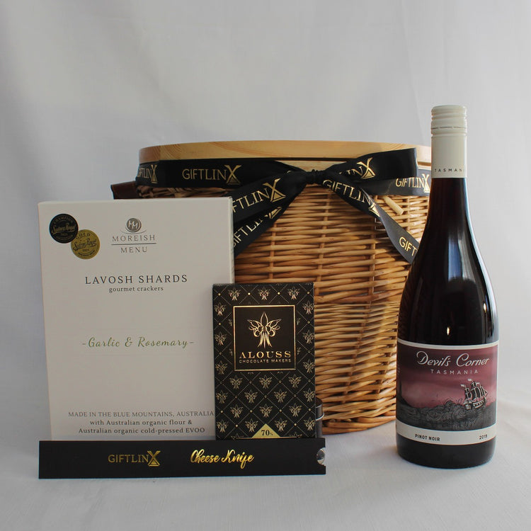 Insulated Wicker picnic basket with Australian wine, lavosh shards, handmade chocolate and stainless steel cheese knife.