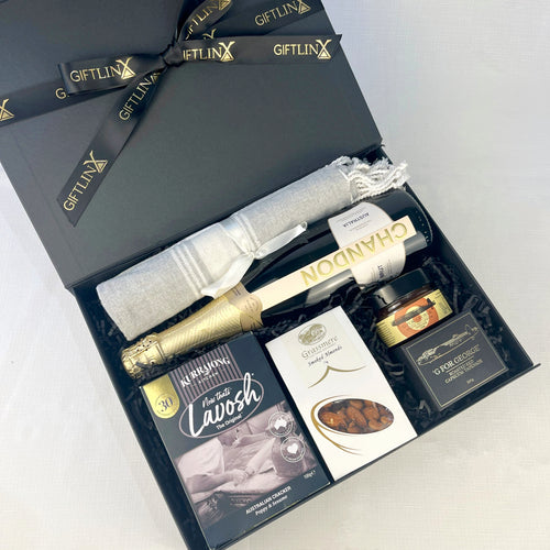Gift set with champagne, cheese, and other items in a black box labeled 'GIFTLINX'.