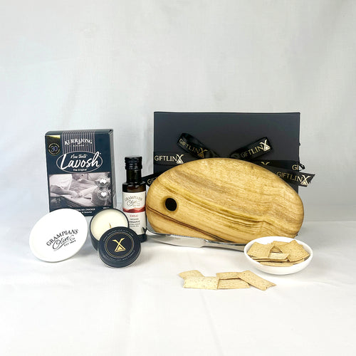 Collection of luxury items including a wooden cutting board, candles, and other products on a white background.
