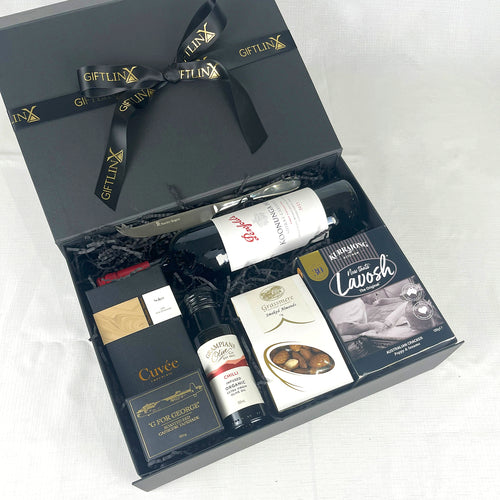 Gift box with wine and other items on a white background