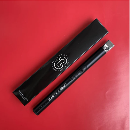 A black rechargable candle lighter next to a black box on red background