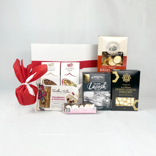 Assorted food items including a box of tea, cookies, and popcorn on a white background