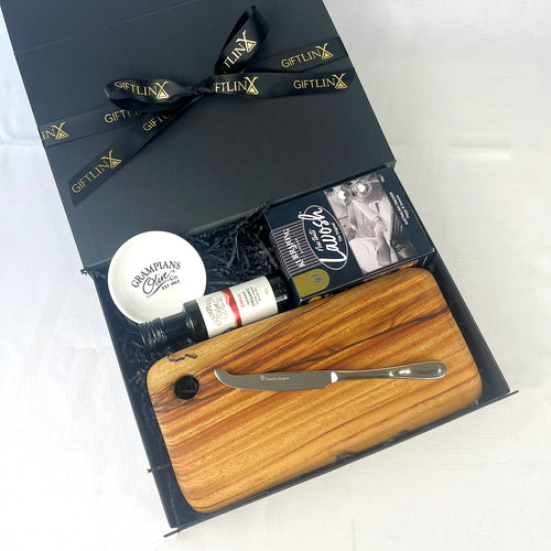 Gift set with a wooden cutting board, knife, and other items in a black box labeled 'GIFTLINX'.