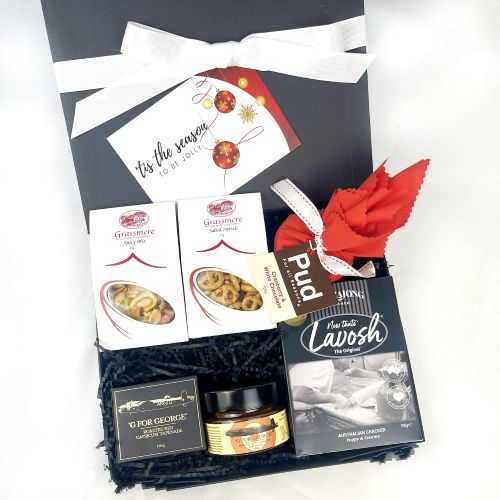 savoury christmas hamper including christmas pudding, crackers, tapenade and savoury snack in box on white background