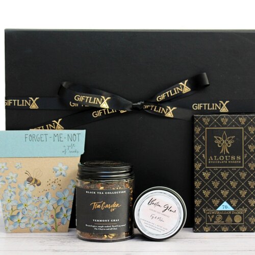 A small sympathy gift hamper with premium Australian chocolate, loose leaf tea jar, luxury soy candle tin and a packet of 'forget me not' seeds