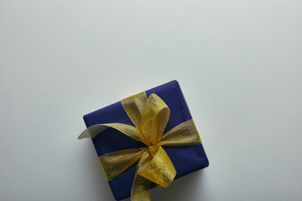 White background with a gift box and ribbon positioned in the middle