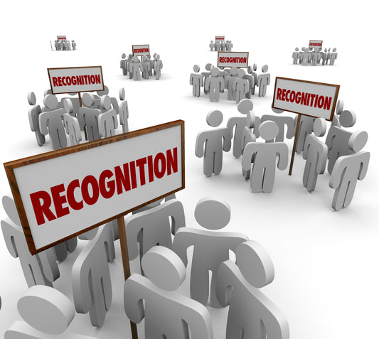 Cartoon image of white human figurines holding up signs that say "recognition"