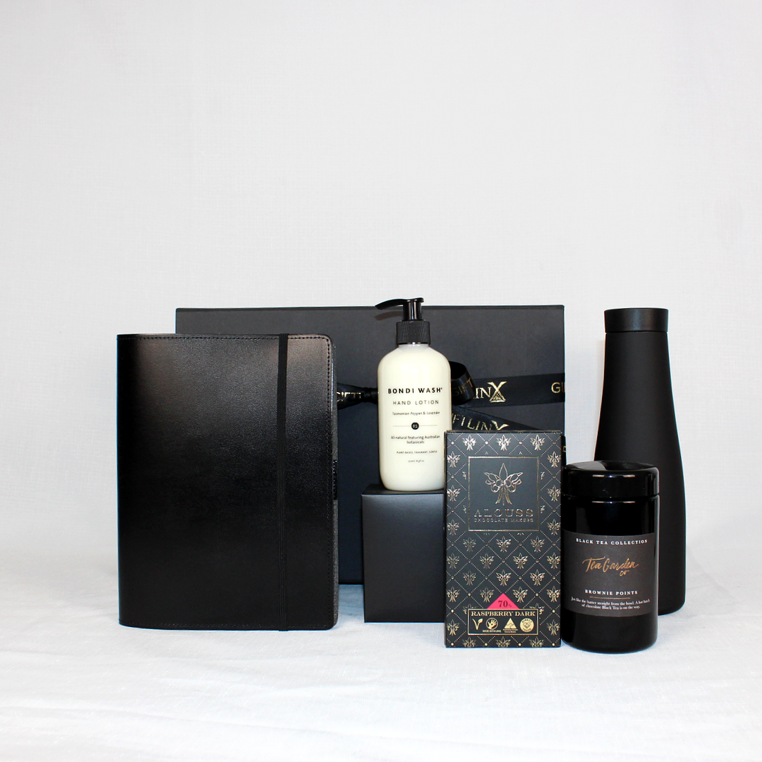 Black gift box with sustainable leather journal  made from recycled leather with a recycled paper notebook, reusable drink flask, chocolate, hand lotion and Australian loose leaf tea