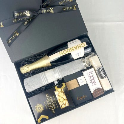 Gift set with champagne, truffles, and other items in a black box labeled 'GIFTLINX'.