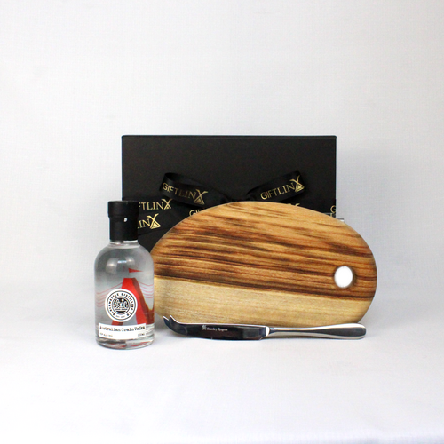 black gift box standing behind a bottle of Australian vodka, a timber serving board and stainless steel cheese knife