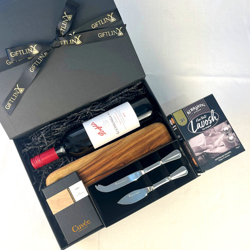 Wine gift set with bottle, wooden stopper, and cheese knives in a black box labeled 'GIFTLINX'.
