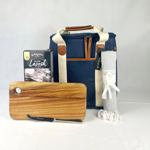 Set of items including a wooden cutting board with knife, blue insulated lunch bag, and rolled towel on a light gray background.