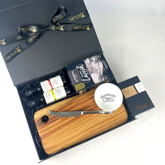 Gift set with a wooden cutting board, knife, and other items in a black Giftlinx box.
