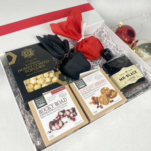 Gift set with popcorn, chocolate bars, and coffee in a decorative box.
