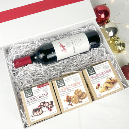 Wine gift set with a bottle of wine and three boxes of cookies and rocky road in a decorative box.