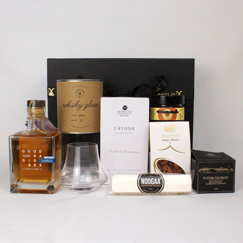 black gift box standing behind a bottle of goodradigbee whisky and a handblown whisky glass, lavosh, nougat bar, smoked almonds and a jar of tapenade in black and gold box