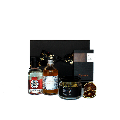 black gift box standing behind a bottle of Australian Vodka, lime syrup , dried lime slices and a block of chocolate in black packaging