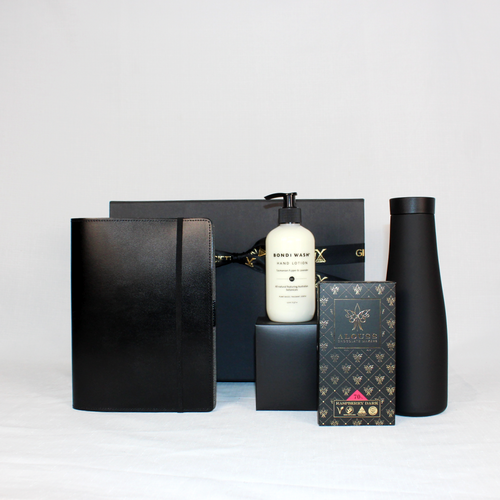 Black leather notepad holder with a black drink flask, Australian made chocolate and Australian botanical hand lotion packaged in a black gift box with ribbon