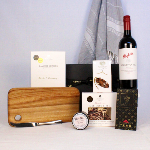 Australian wine, chocolate and meringue pieces, smoked almonds, lavosh shards, handmade timber cheese board with cheese knife, luxury hand poured candle and a 100% cotton hand towel all presented in a luxury black gift box with ribbon