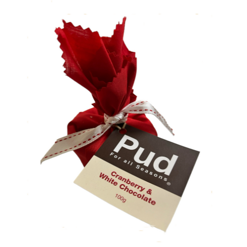 Small pudding in red calico wrap with ribbon and label on white background