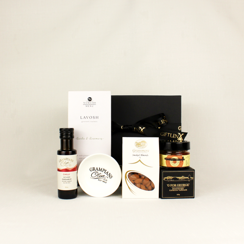 a black gift box behind a range of savoury food items like infused olive oil, lavosh crackers, nuts and capsicum tapenade