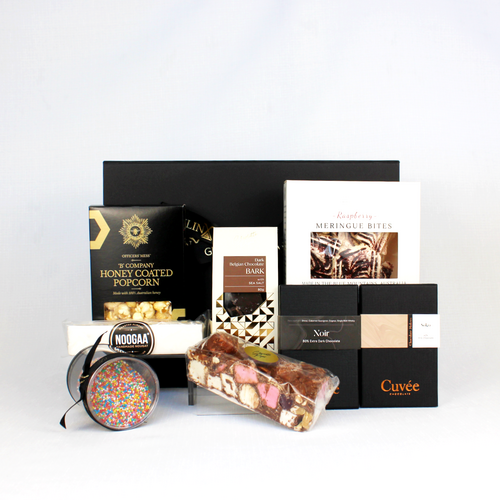 a black gift box standing behind a range of Australian made sweets like rocky road, nougat, chocolate, meringue and honey coated popcorn