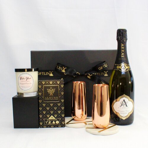 Australian sparkling wine with copper champange flutes on marble coasters with Australian handmade chocolate and luxury soy candle jar packaged in elegant black magnetic box