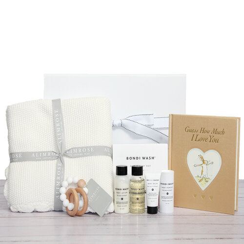 New born baby hamper with a soft weave blanket, timber teething ring, baby bath products and 'guess how much i love you' baby book
