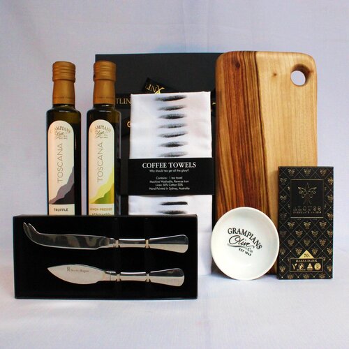 Gift hamper with handmade timber cheese board, stainless steel cheese knife set, infused olive oil x2 and dipping bowl, linen blend kitchen towel and premium Australian chocolate