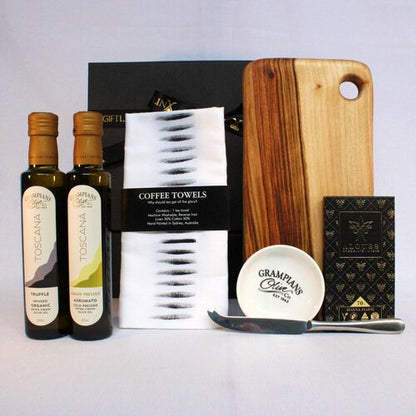 Guft hamper with handmade timber cheese board, single stainless steel cheese knife, infused olive oil x2 and dipping bowl, linen blend kitchen towel and premium Australian chocolate