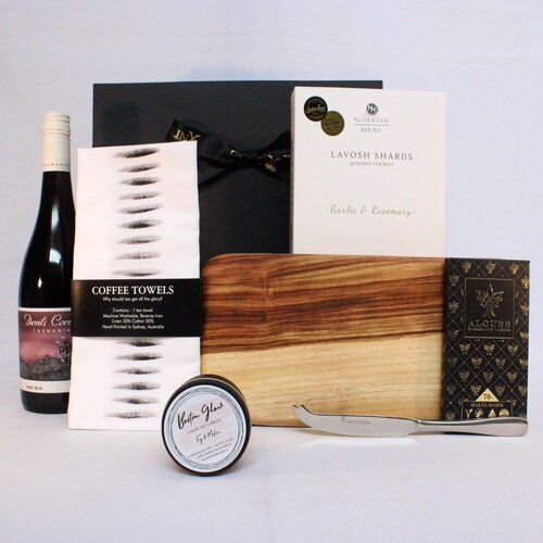 Gift hamper with handmade timber cheese board, single stainless steel cheese knife , lavosh shards, linen blend kitchen towel, premium Australian chocolate, luxury soy candle and wine